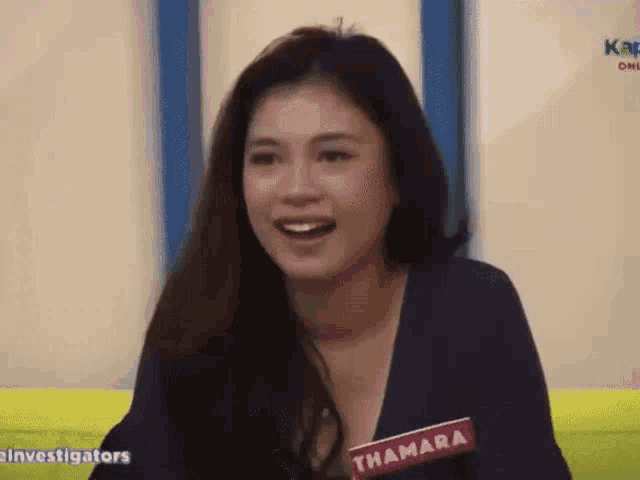 a woman wearing a name tag that says thamara