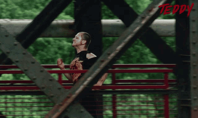 a man is running across a bridge with the word teddy on the bottom