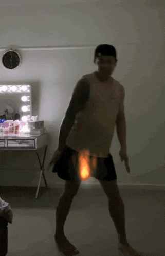 a man dancing in front of a mirror with a clock on the wall