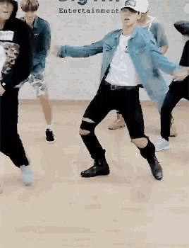 a group of people are dancing in front of a wall that says entertainment