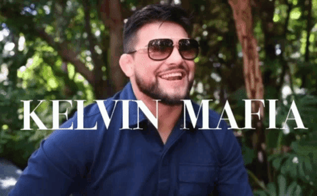 a man wearing sunglasses and a blue shirt with the name kelvin mafia