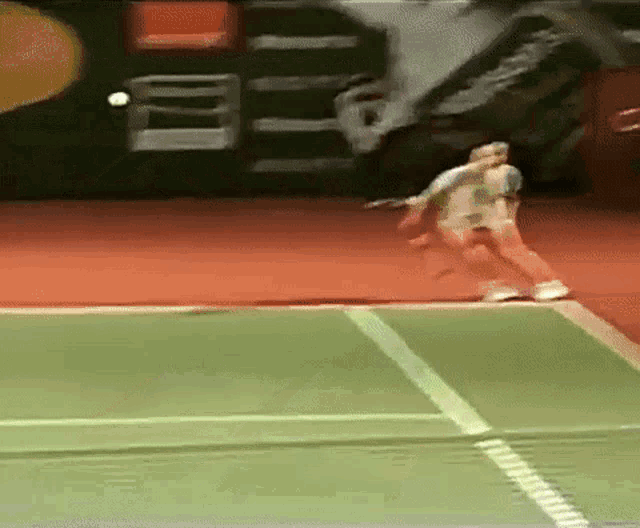 a tennis player is swinging a racket at a ball