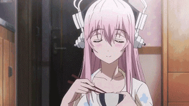 a girl with pink hair is wearing headphones and eating from a cup with chopsticks .
