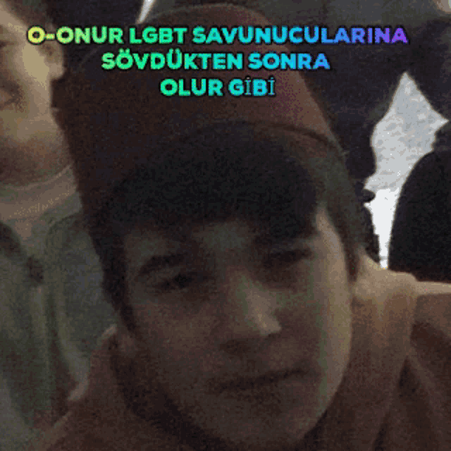 a boy wearing a red hat with the words " o-onur lgbt savunucularina " on the top