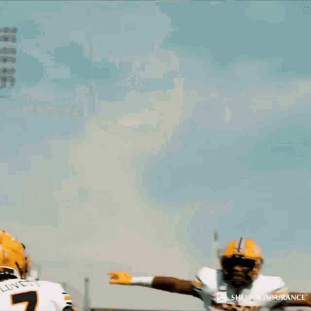 two football players are jumping in the air in front of a crowd