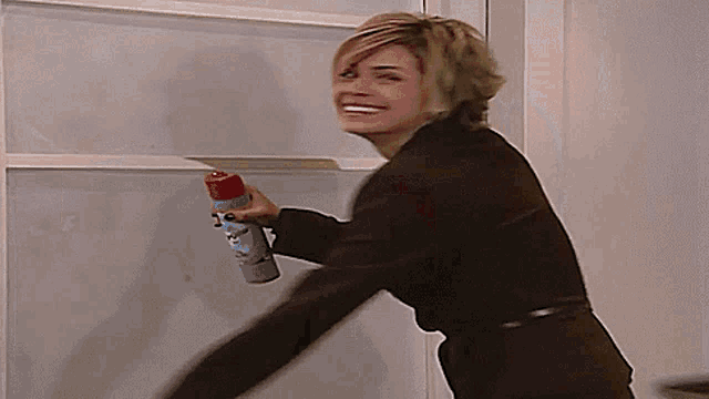 a woman in a brown jacket is holding a spray bottle that says ' dawn ' on it
