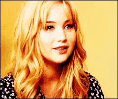 a woman with blonde hair is wearing a black and white polka dot shirt