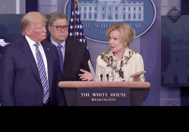 two men and a woman stand behind a podium that says the white house