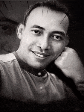 a black and white photo of a smiling man with his hand on his chin