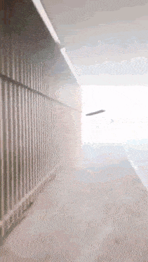 a blurred image of a tunnel with a white wall and a white line on the floor