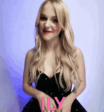 a woman in a black dress with the word ily written on her chest