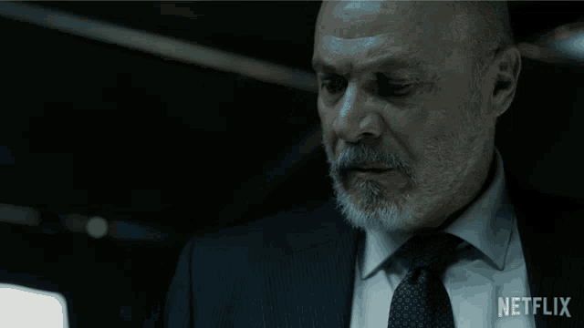 a man in a suit and tie with a netflix logo on the bottom