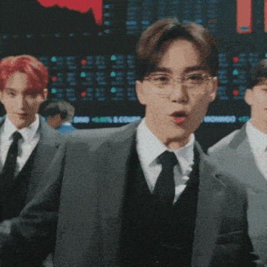 a man in a suit and tie stands in front of a screen that says wonwoo on it