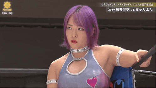 a woman with purple hair is standing in a wrestling ring with the hashtag #fw_mg