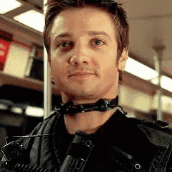 a man wearing headphones around his neck is standing in a train