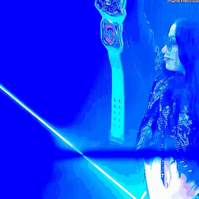 a woman is holding a championship belt in front of a bright blue background