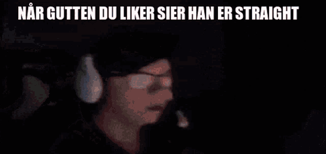 a man wearing headphones and a hat with the words " nar gutten du liker sier han er straight " on the bottom