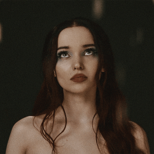 a close up of a woman 's face with long red hair