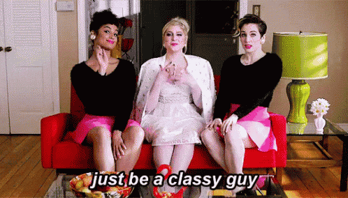 three women are sitting on a red couch with the words just be a classy guy