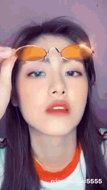 a woman is wearing sunglasses on her forehead and making a face .