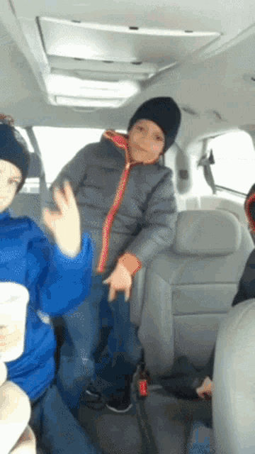 a group of children are sitting in the back of a van