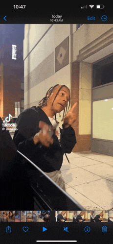 a phone screen shows a tiktok video of a man giving a middle finger