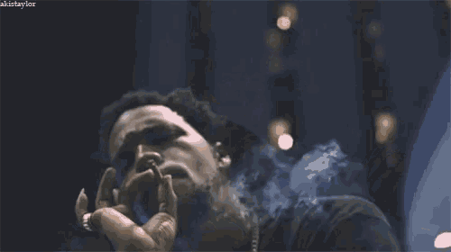 a man is smoking a cigarette with smoke coming out of his mouth and nose .