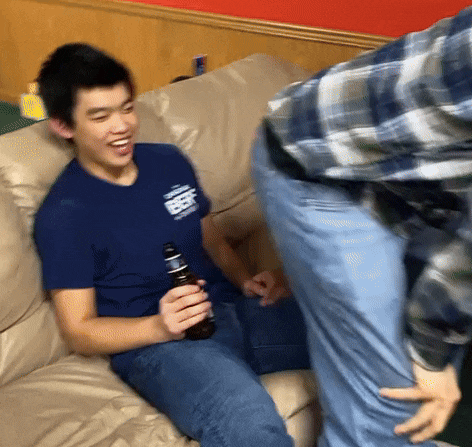 a man sitting on a couch with a bottle of beer