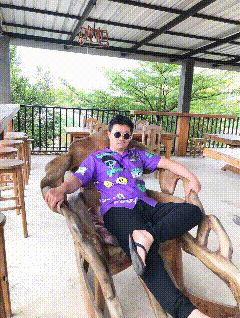 a man in a purple shirt is sitting in a chair