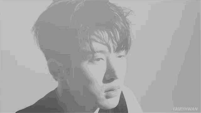 a black and white photo of a young man with his eyes closed