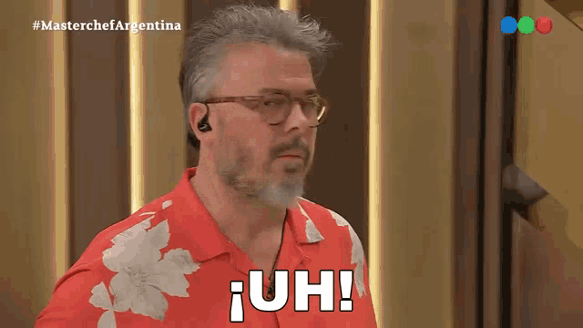 a man wearing glasses and a red shirt says uh on the screen