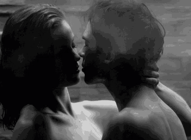 a man and a woman kissing in a bathtub