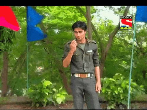 a man in a military uniform is smoking a cigarette in front of a sony advertisement