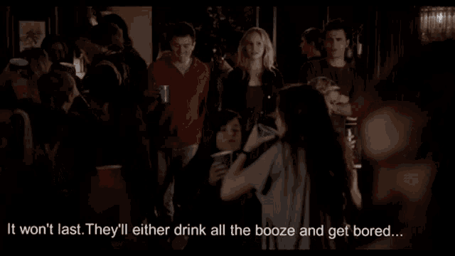 a man and a woman are standing next to each other in a dark room and the man is talking about damon