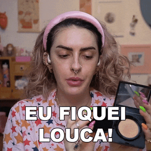 a woman with a pink headband is holding a makeup palette and says " eu fiquei louca "
