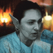 a woman with elf ears is wearing a sweater and earrings