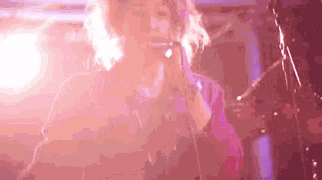 a woman is singing into a microphone while playing a saxophone on stage .