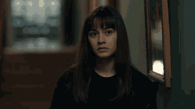 a woman with long hair and bangs is looking at the camera
