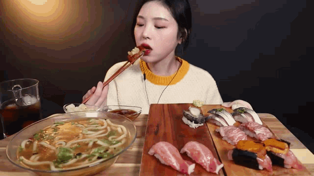 a woman is eating noodles and sushi at a table with chopsticks