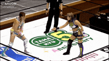 two female wrestlers are standing on a mat that says tama kyu on it