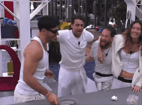 a group of people in white shirts are standing around a counter