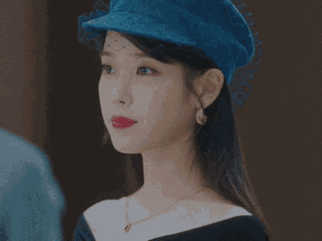a close up of a woman wearing a blue hat with a veil
