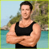 a man in a black tank top is standing with his arms crossed .
