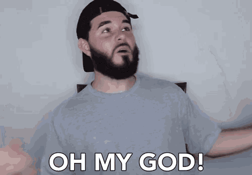 a man with a beard wearing a hat and a grey shirt says oh my god