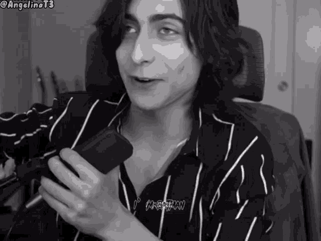 a black and white photo of a young man wearing a striped shirt with the word argentine on it