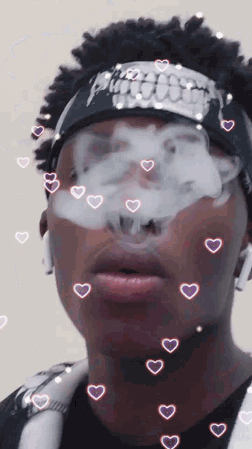 a man wearing a bandana with skulls on it smoking a cigarette