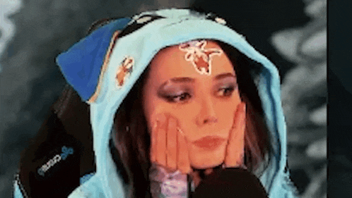 a woman wearing a blue hoodie with a flower on her forehead .