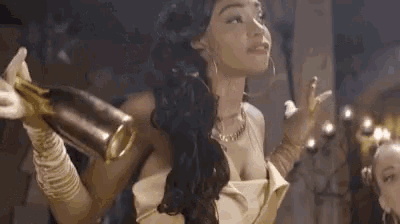 a woman dressed as wonder woman is holding a bottle of champagne .