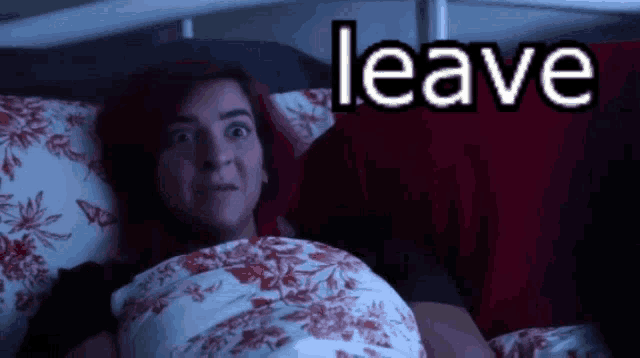 a woman with red hair is laying in bed with the word leave behind her
