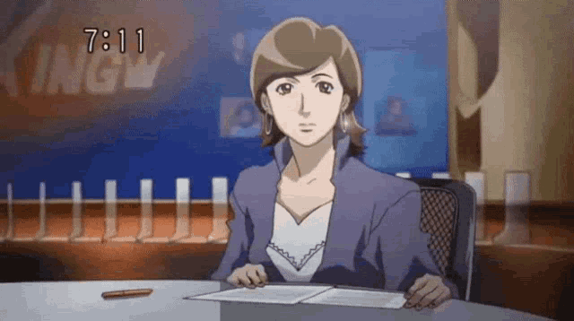 a woman sits at a desk in front of a sign that says 7:11 on it